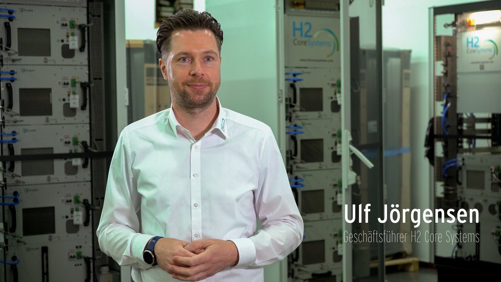 Ulf Jorgensen steht neben H2 Core Systemen und blickt in die Kamera.